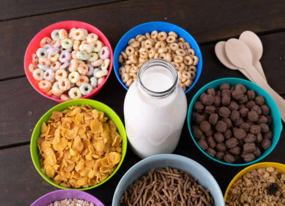 High angle view of various breakfast cereals in bowls arranged with milk bottle on table. unaltered, breakfast, variation, healthy food, snack and food concept.