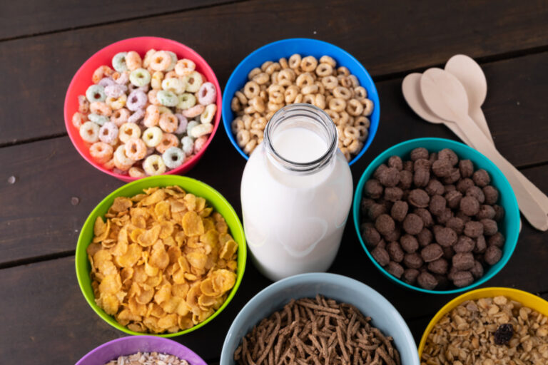High angle view of various breakfast cereals in bowls arranged with milk bottle on table. unaltered, breakfast, variation, healthy food, snack and food concept.